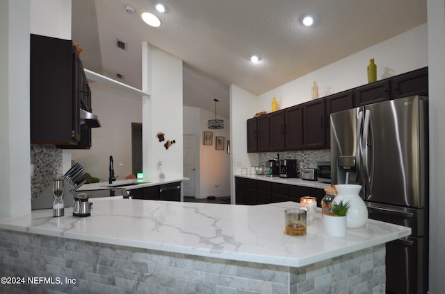 kitchen with kitchen peninsula, stainless steel refrigerator with ice dispenser, a textured ceiling, and light stone countertops