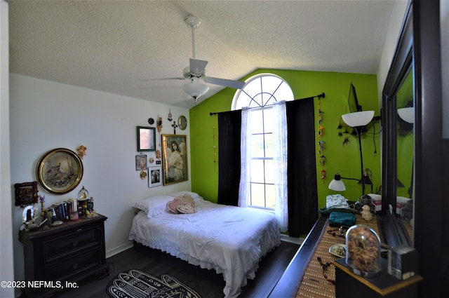 bedroom featuring a textured ceiling, vaulted ceiling, ceiling fan, and dark wood-type flooring