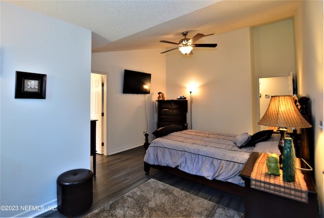 bedroom featuring lofted ceiling, ceiling fan, dark hardwood / wood-style floors, and a textured ceiling