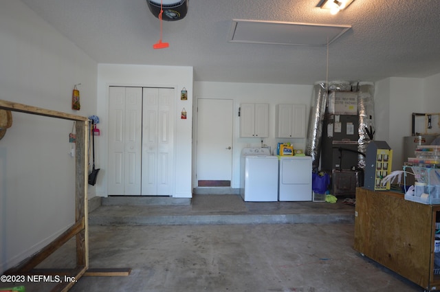 garage with separate washer and dryer and a garage door opener