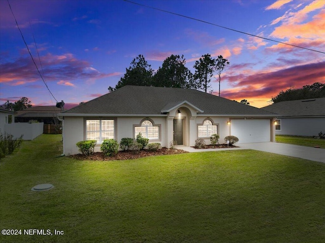 ranch-style house with a garage and a lawn