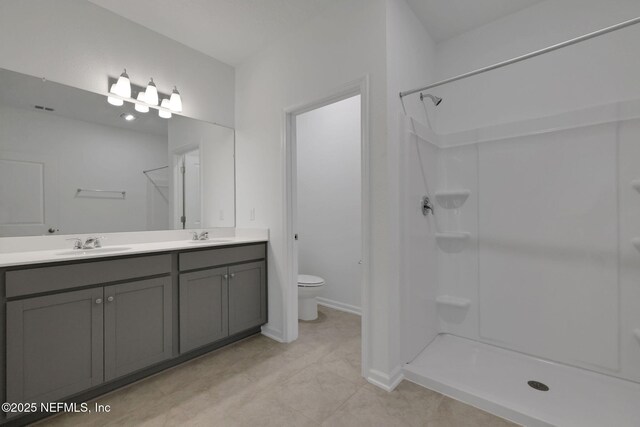 bathroom featuring a shower, vanity, and toilet