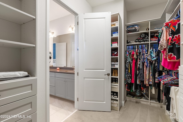 spacious closet with light carpet and sink