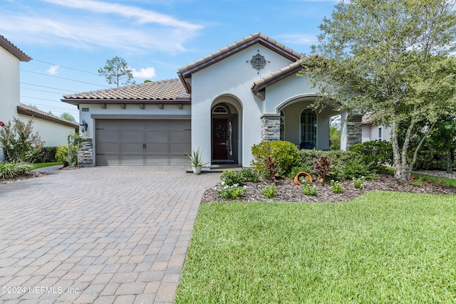 mediterranean / spanish-style house with a garage and a front lawn