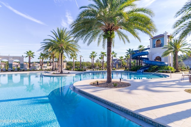 view of swimming pool featuring a water slide and a patio