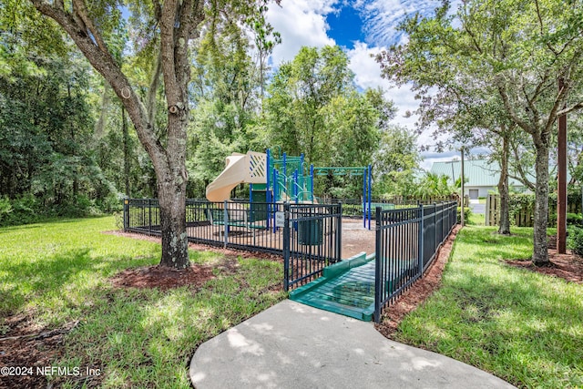 view of home's community with playground community, fence, and a lawn