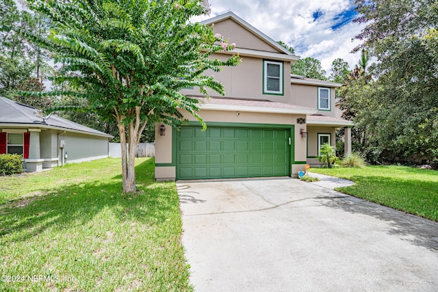 view of front facade with a front yard, concrete driveway, and stucco siding