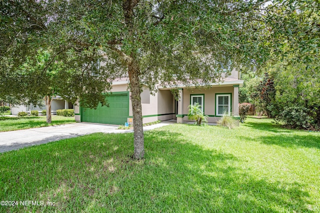 view of property hidden behind natural elements with a front lawn and a garage