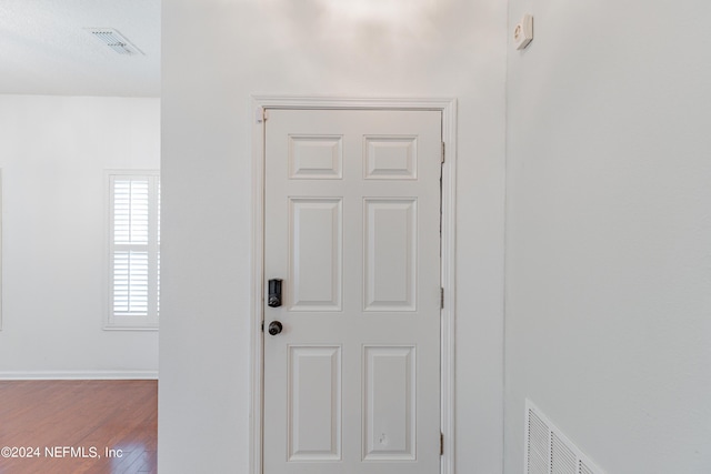 entryway with wood finished floors, visible vents, and baseboards