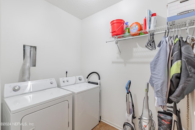 laundry room with laundry area, independent washer and dryer, and a textured ceiling