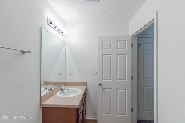 bathroom with a textured ceiling and vanity