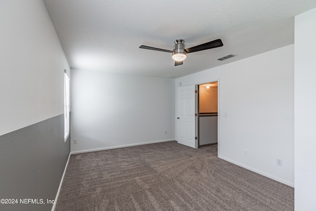 carpeted spare room featuring a textured ceiling and ceiling fan