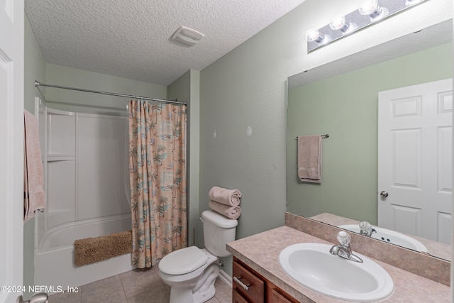 full bathroom featuring a textured ceiling, toilet, shower / bath combo, tile patterned flooring, and vanity