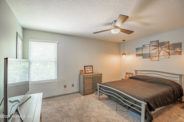 bedroom with a textured ceiling, baseboards, a ceiling fan, and light colored carpet