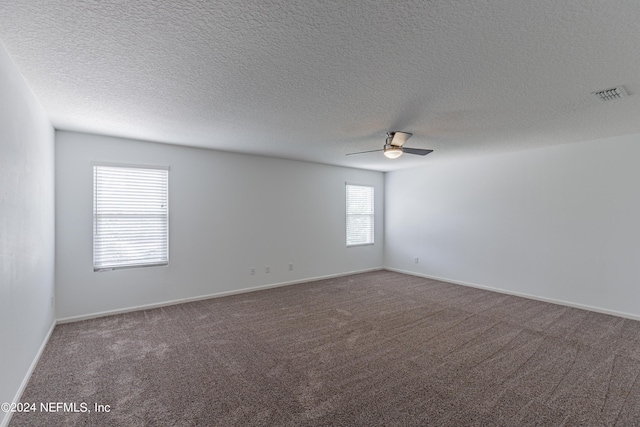 unfurnished room featuring a textured ceiling, carpet flooring, visible vents, baseboards, and a ceiling fan