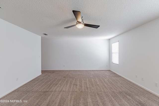 unfurnished room featuring baseboards, visible vents, a ceiling fan, carpet, and a textured ceiling