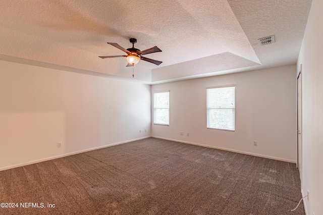 empty room featuring a textured ceiling, carpet, visible vents, and baseboards