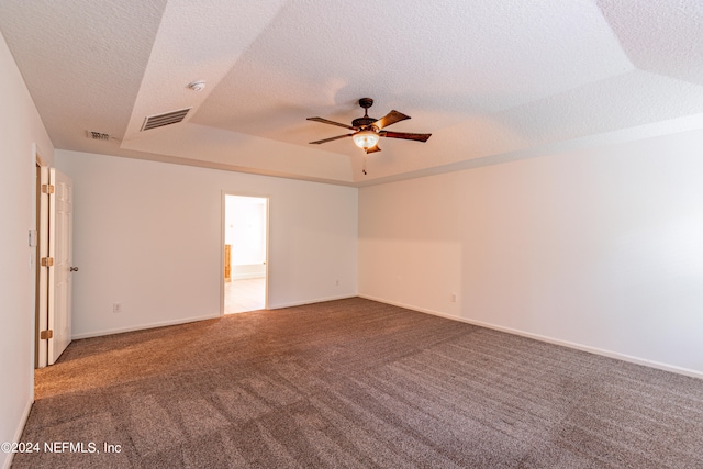 carpeted empty room featuring ceiling fan, a textured ceiling, and a tray ceiling