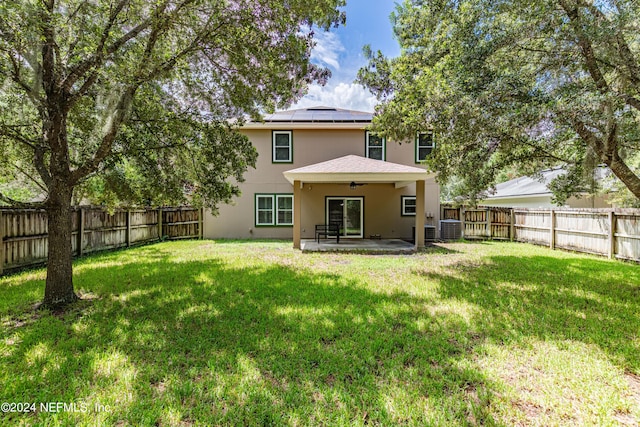 rear view of property with a fenced backyard, a patio, cooling unit, and a yard