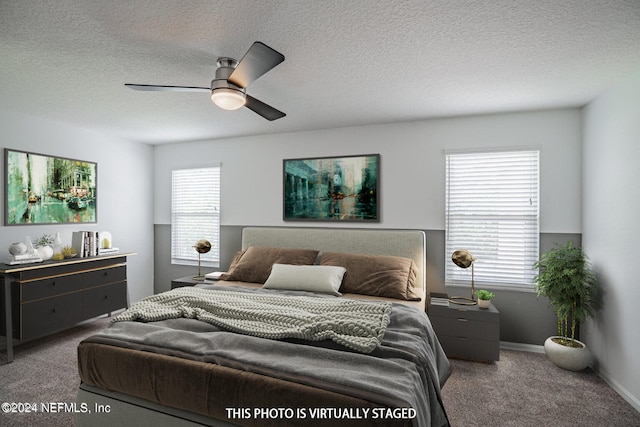 bedroom with a textured ceiling, carpet flooring, ceiling fan, and multiple windows