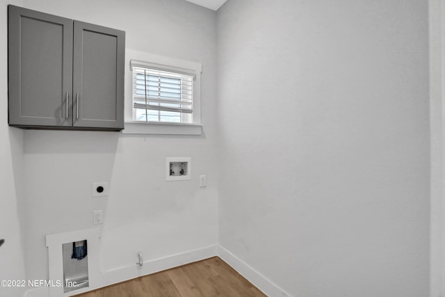 washroom featuring hookup for a gas dryer, electric dryer hookup, hookup for a washing machine, cabinets, and light hardwood / wood-style flooring