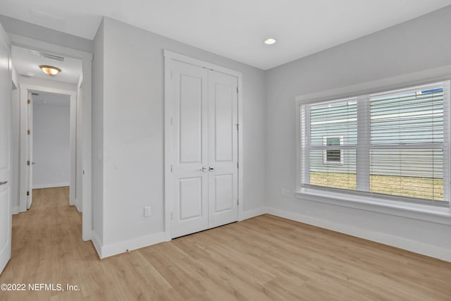 unfurnished bedroom featuring a closet and light hardwood / wood-style flooring