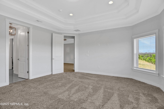 unfurnished bedroom featuring ornamental molding, a raised ceiling, and carpet floors