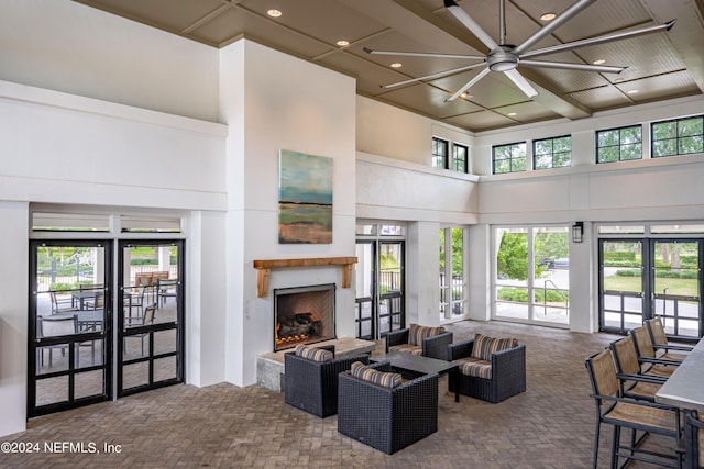 living room featuring ceiling fan, a towering ceiling, and french doors