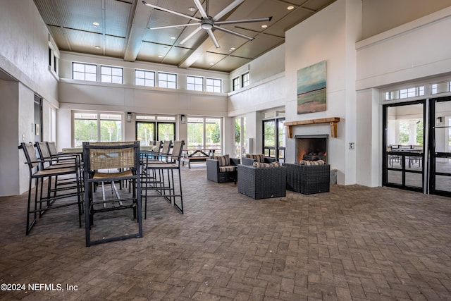 dining area with ceiling fan, a wealth of natural light, and a high ceiling