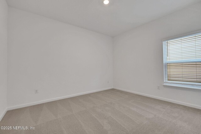 spare room featuring light colored carpet