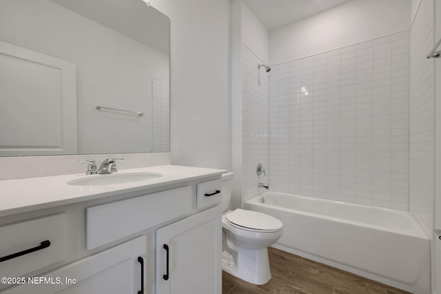 full bathroom featuring vanity, wood-type flooring, toilet, and tiled shower / bath