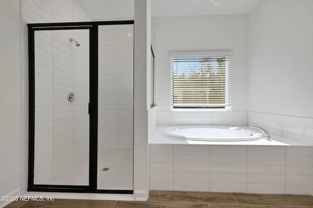 bathroom featuring hardwood / wood-style flooring and separate shower and tub