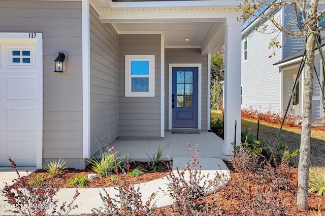 entrance to property with a porch and a garage