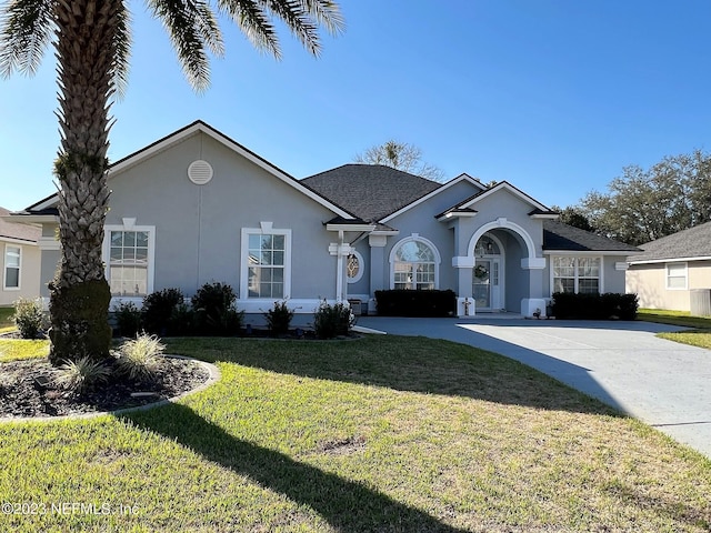 ranch-style house with a front yard and stucco siding