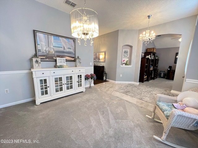 living area featuring light carpet, baseboards, visible vents, an inviting chandelier, and a textured ceiling