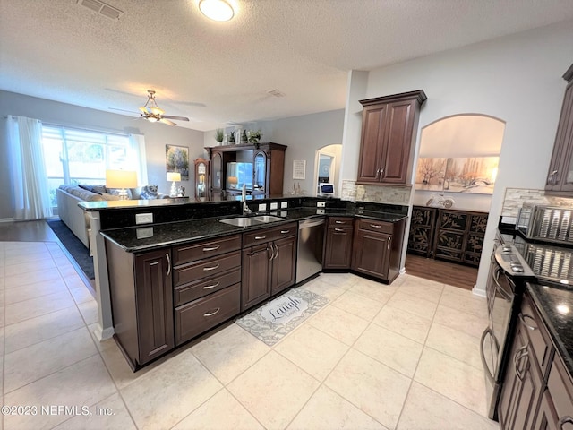 kitchen featuring dark brown cabinetry, visible vents, open floor plan, a peninsula, and stainless steel appliances