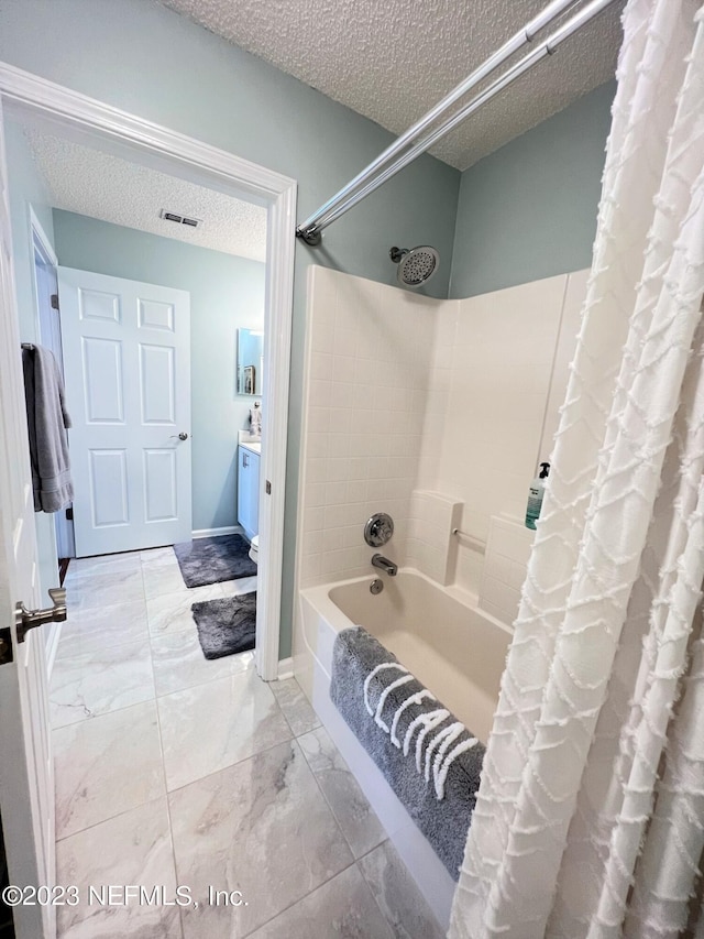 bathroom featuring marble finish floor, visible vents, shower / tub combo, a textured ceiling, and vanity