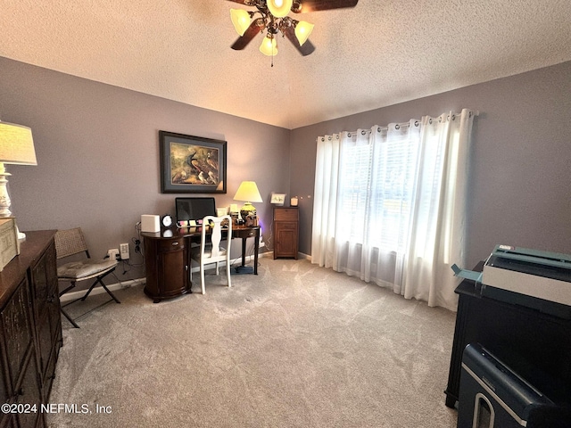 office space with a textured ceiling, carpet floors, a ceiling fan, and baseboards