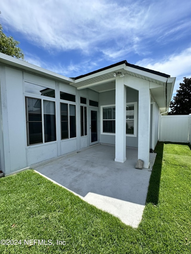 back of house with a lawn, fence, and a patio