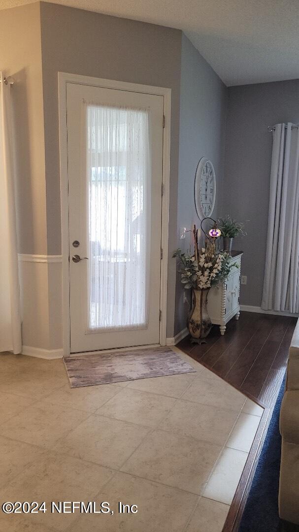 doorway to outside with baseboards and tile patterned floors