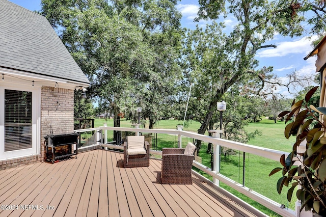 wooden deck featuring a lawn