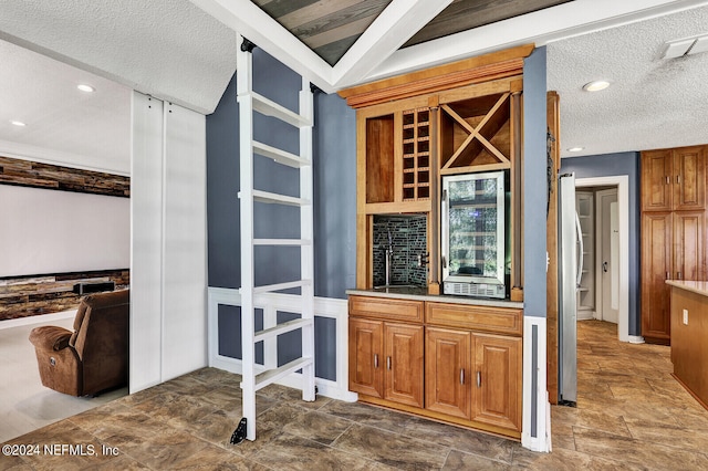 bar with a textured ceiling and beverage cooler