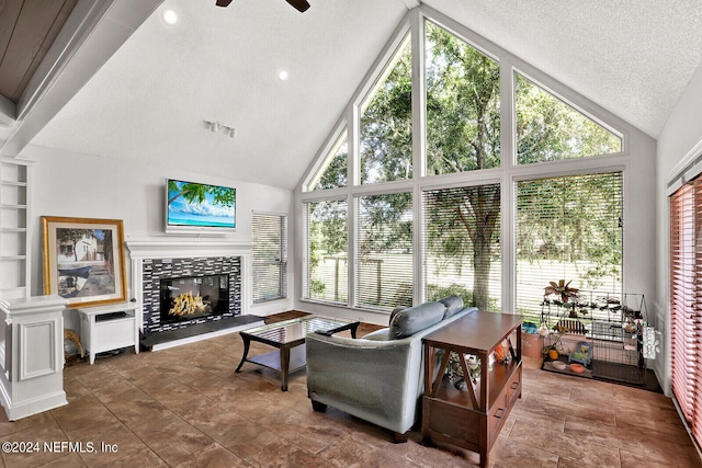 living room with ceiling fan, built in shelves, a healthy amount of sunlight, and a tile fireplace