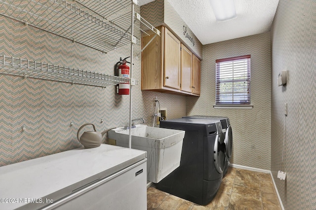 laundry area with cabinets, sink, and washing machine and clothes dryer