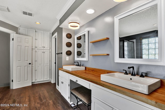 bathroom with vanity, a textured ceiling, hardwood / wood-style flooring, and crown molding