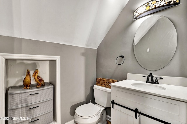 bathroom with vanity, toilet, and lofted ceiling