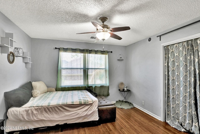 bedroom with wood-type flooring, a textured ceiling, and ceiling fan