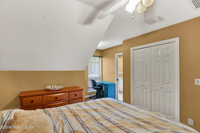 bedroom with a textured ceiling, a closet, lofted ceiling, and ceiling fan