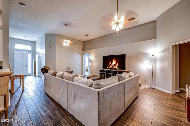 living area featuring a ceiling fan, visible vents, and dark wood-style flooring