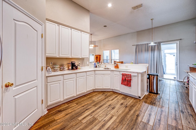 kitchen featuring white cabinetry, decorative light fixtures, wood-type flooring, dishwasher, and kitchen peninsula